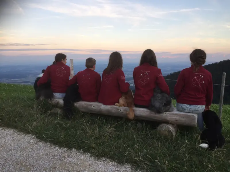 Eine Gruppe von Menschen, die auf einer Bank sitzen. – Jugend und Hund Lager 2017 in Balmberg