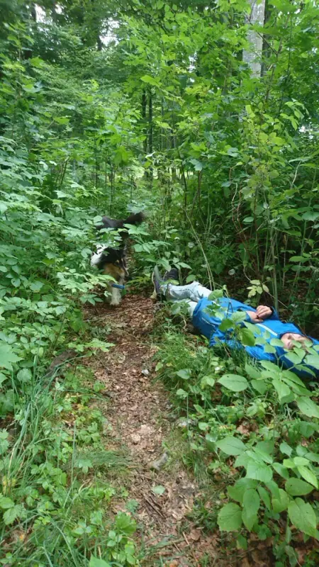 Ein Mann, der mit einem Rucksack im Wald liegt. – Jugend und Hund Lager 2017 in Balmberg