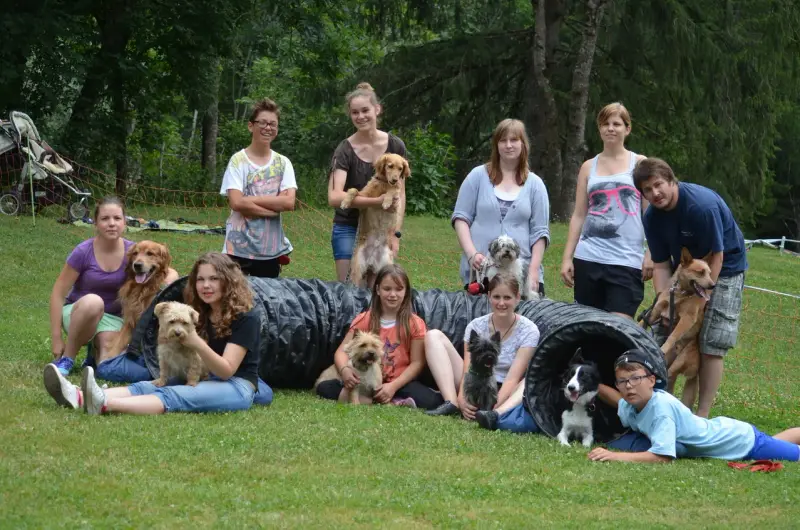 Eine Gruppe von Menschen und ihren Hunden posiert für ein Bild. – Jugend und Hund Lager 2013 in Chur