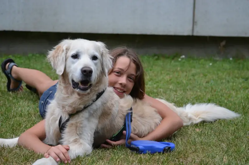 Eine Frau, die mit einem Hund auf dem Gras liegt. – Jugend und Hund Lager 2013 in Chur