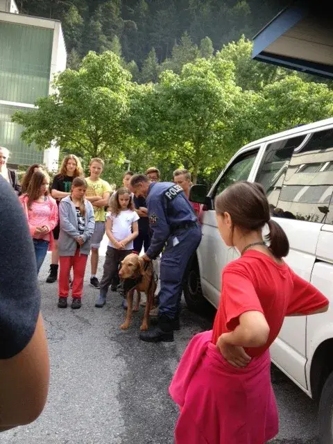 Eine Gruppe von Menschen, die um einen weissen Van stehen. – Jugend und Hund Lager 2014 in Chur