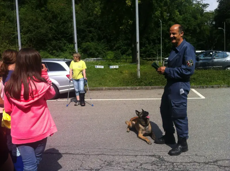 Ein Polizist spricht mit einem Kind. – Jugend und Hund Lager 2014 in Chur