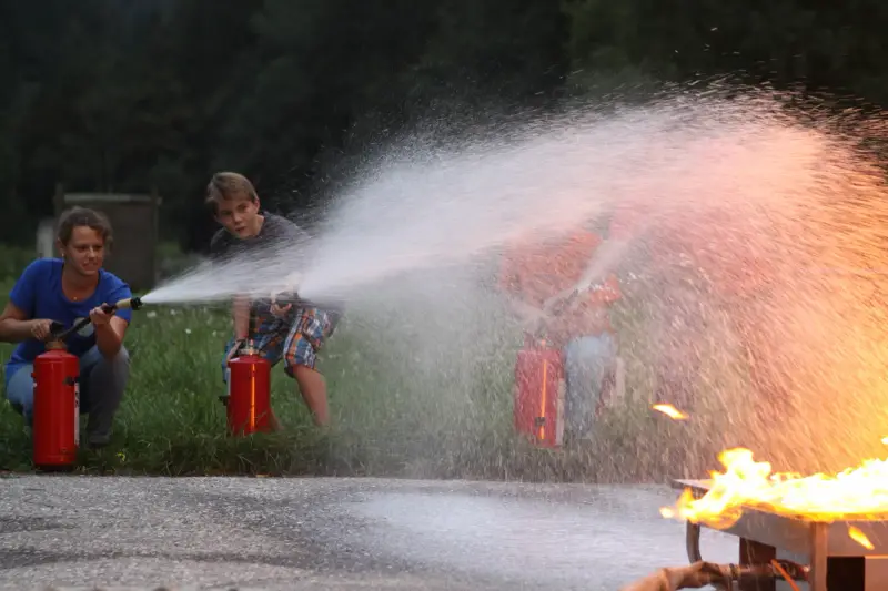 Eine Gruppe von Menschen, die um eine Feuer-Hydraulik stehen. – Jugend und Hund Lager 2014 in Chur