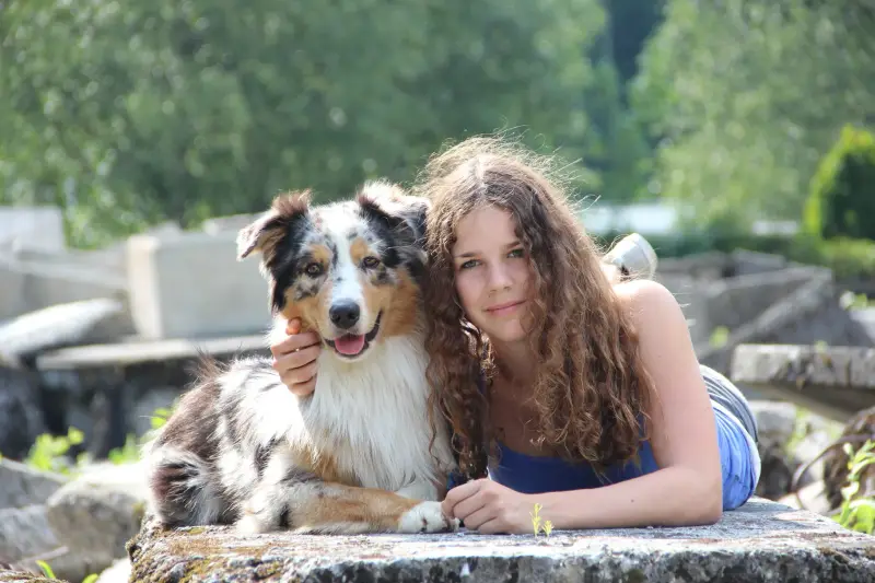 Eine Frau legt sich mit einem Hund nieder. – Jugend und Hund Lager 2014 in Chur