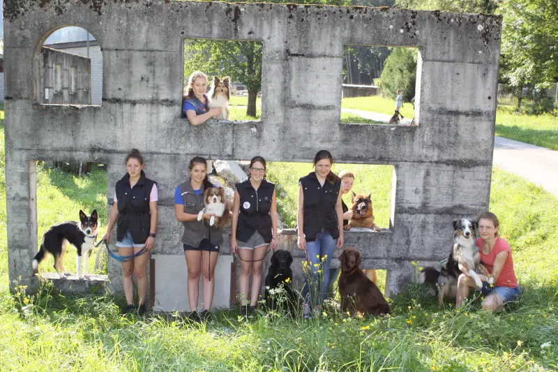 Eine Gruppe von Menschen und ihren Hunden posiert für ein Bild. – Jugend und Hund Lager 2014 in Chur