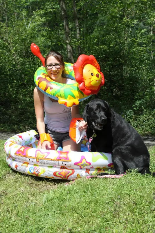 Eine Frau, die in einem Pool mit einem Hund sitzt. – Jugend und Hund Lager 2014 in Chur