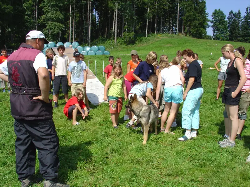 Eine Gruppe von Menschen, die um ein Schwein stehen. – Jugend und Hund Lager 2005 in Ebnatkappel