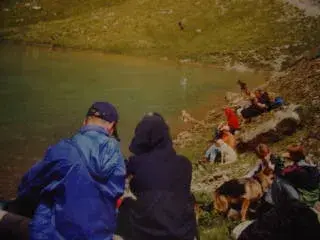 Eine Gruppe von Menschen, die auf dem Boden sitzen. – Jugend und Hund Lager 2002 in Lenzerheide