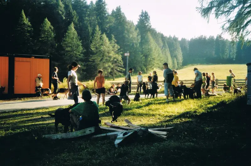 Eine Gruppe von Menschen, die auf dem Gras sitzen. – Jugend und Hund Lager 2002 in Lenzerheide