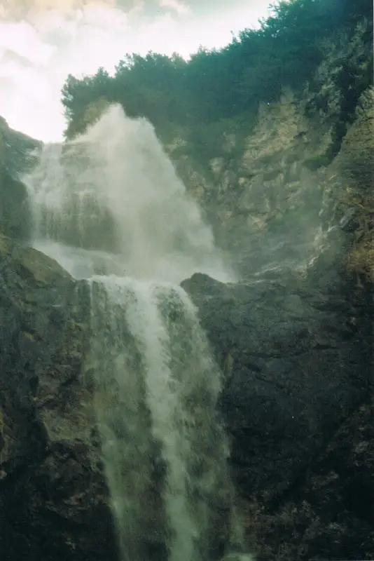 Ein Wasserfall mit einem Mann, der vor ihm steht. – Jugend und Hund Lager 2002 in Lenzerheide