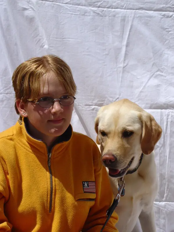 Ein junger Junge sitzt neben einem Hund. – Jugend und Hund Lager 2003 in Lenzerheide