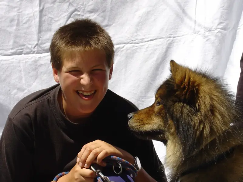 Ein Junge und ein Hund sitzen auf einem Tisch. – Jugend und Hund Lager 2003 in Lenzerheide