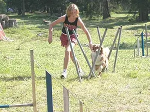 Ein junges Mädchen springt über eine Hürde. – Jugend und Hund Lager 2003 in Lenzerheide