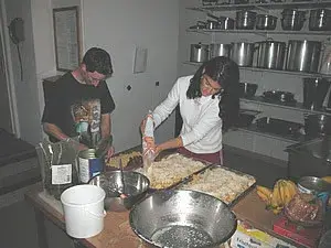 Ein paar Leute in einer Küche, die Essen zubereiten. – Jugend und Hund Lager 2003 in Lenzerheide