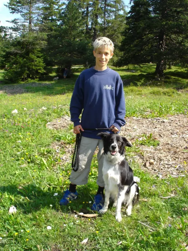 Ein Junge und sein Hund auf einem Feld. – Jugend und Hund Lager 2004 in Lenzerheide
