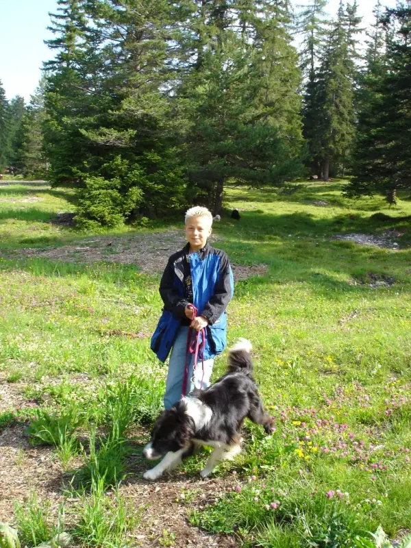 Ein Junge, der einen Hund auf einem Feld läuft. – Jugend und Hund Lager 2004 in Lenzerheide