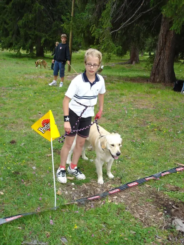 Ein junges Mädchen spielt mit einem Hund. – Jugend und Hund Lager 2004 in Lenzerheide
