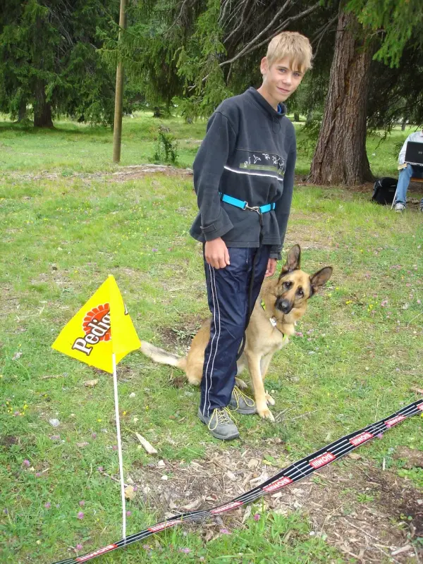 Ein Junge und sein Hund spielen mit einem Spielzeug. – Jugend und Hund Lager 2004 in Lenzerheide