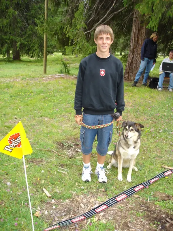 Ein junger Junge steht neben einem Hund. – Jugend und Hund Lager 2004 in Lenzerheide