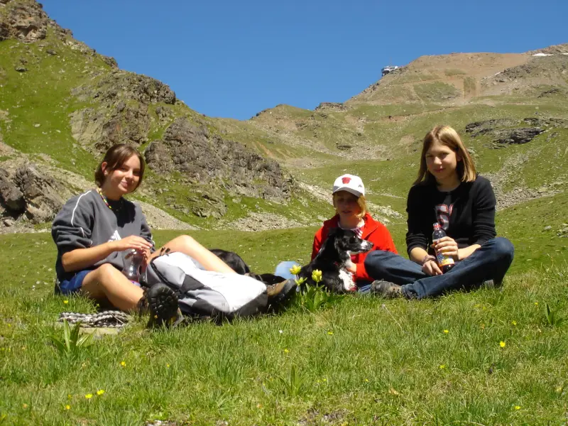 Eine Frau und ein Kind sitzen auf dem Gras. – Jugend und Hund Lager 2004 in Lenzerheide