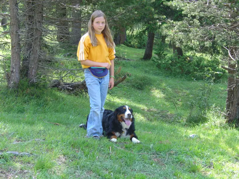 Ein Mädchen, das mit einem Hund im Wald steht. – Jugend und Hund Lager 2004 in Lenzerheide