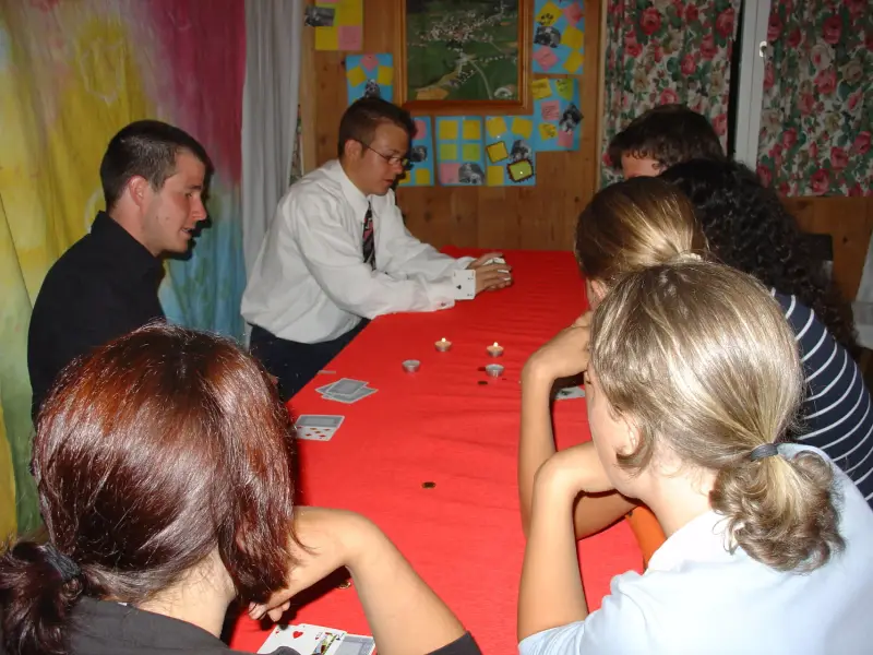 Eine Gruppe von Menschen, die um einen Tisch sitzen. – Jugend und Hund Lager 2004 in Lenzerheide