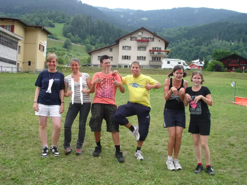 Eine Gruppe von Menschen auf einem üppigen grünen Feld stehen, mit einem Mann in der Mitte halten einen Stock. – Jugend und Hund Lager 2009 in Ruen