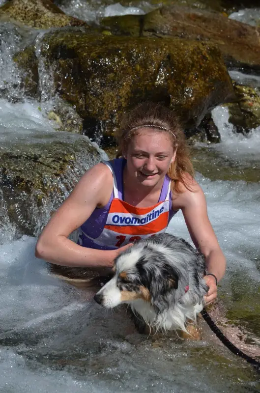 Eine Frau in einer lila Weste spielt mit einem Hund. – Jugend und Hund Lager 2015 in Segnas