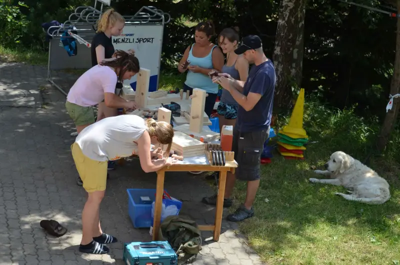 Eine Gruppe von Menschen um einen Tisch versammelt. – Jugend und Hund Lager 2015 in Segnas