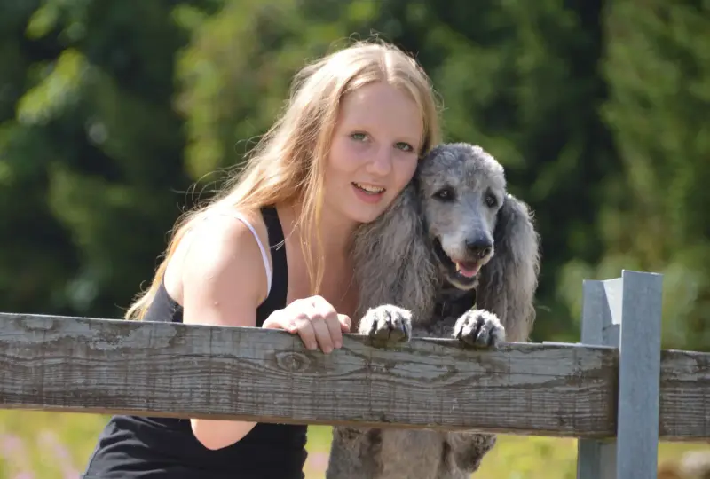 Eine Frau, die sich mit einem Hund an einen Zaun lehnt. – Jugend und Hund Lager 2015 in Segnas