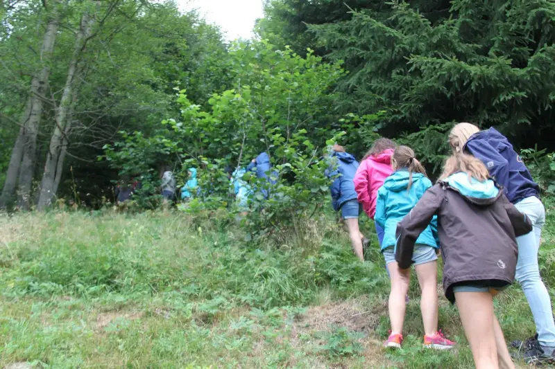 Eine Gruppe von Menschen, die durch einen Wald gehen. – Jugend und Hund Lager 2015 in Segnas