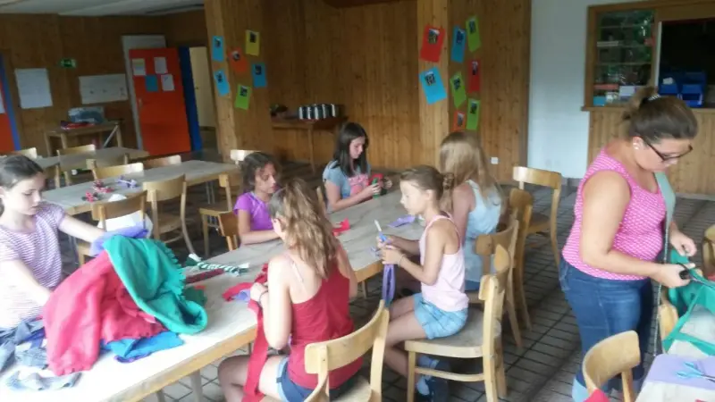 Eine Gruppe von Mädchen, die an einem Tisch sitzen. – Jugend und Hund Lager 2015 in Segnas