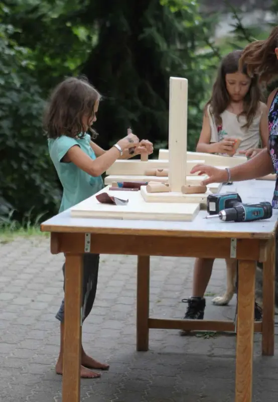 Eine Frau und zwei Kinder sitzen an einem Tisch. – Jugend und Hund Lager 2015 in Segnas