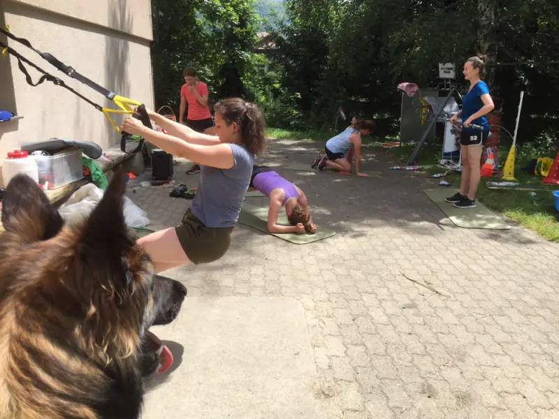 Eine Frau spielt mit einem Hund auf dem Bürgersteig. – Jugend und Hund Lager 2016 in Segnas