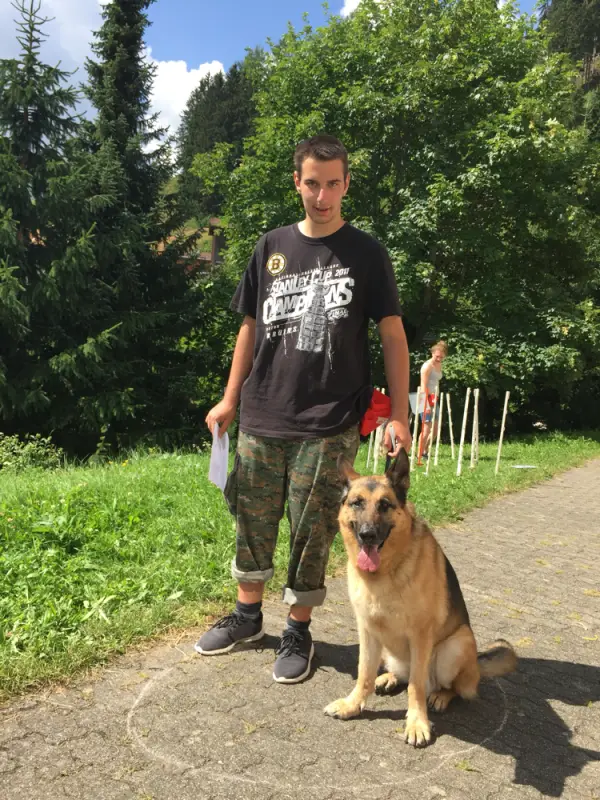 Ein Mann steht neben einem Hund auf einem Pfad. – Jugend und Hund Lager 2016 in Segnas