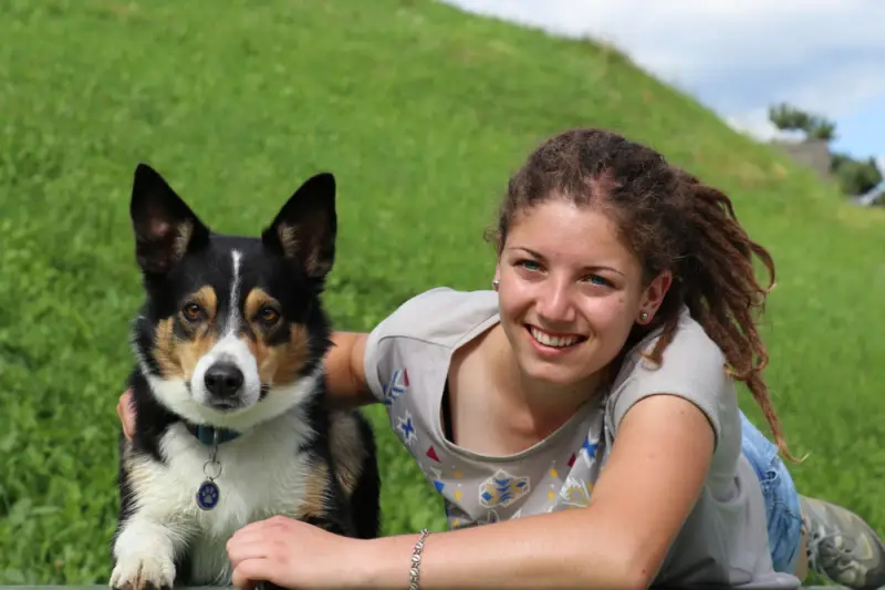 Eine Frau, die mit einem Hund auf einer Bank liegt. – Jugend und Hund Lager 2016 in Segnas