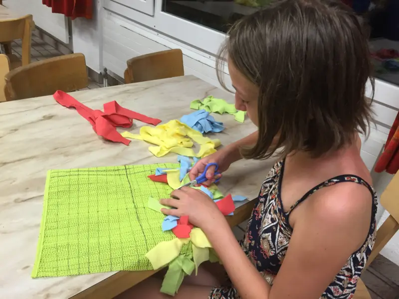 Eine Frau, die mit einem Stück Papier an einem Tisch sitzt. – Jugend und Hund Lager 2016 in Segnas