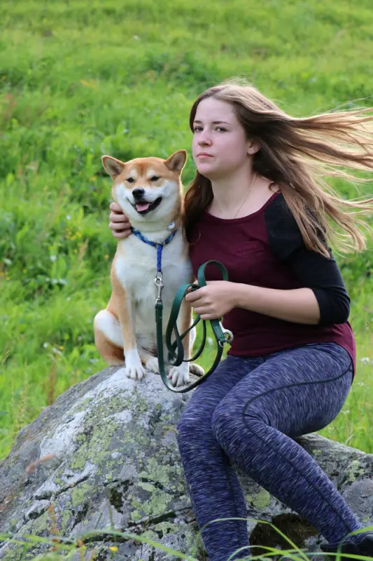 Ein Mädchen sitzt auf einem Felsen mit einem Hund. – Jugend und Hund Lager 2016 in Segnas