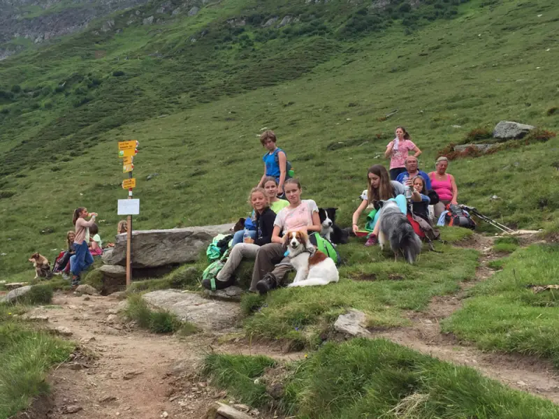 Eine Gruppe von Menschen, die auf einem Hügel sitzen. – Jugend und Hund Lager 2016 in Segnas
