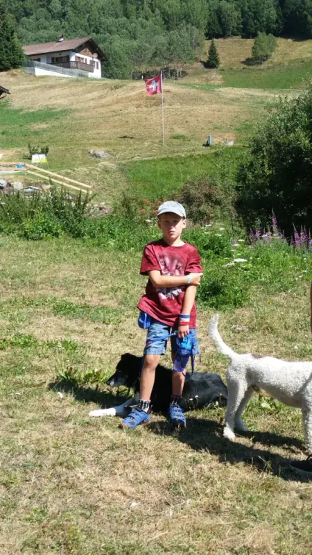 Ein junger Junge, der mit einem Hund auf dem Boden sitzt. – Jugend und Hund Lager 2018 in Segnas