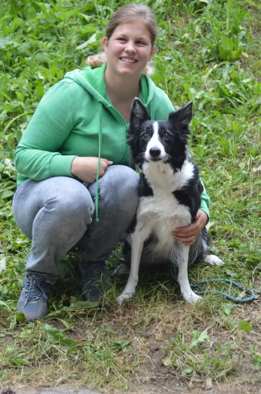 Ein junges Mädchen, das mit einem Hund auf dem Boden sitzt. – Jugend und Hund Lager 2018 in Segnas