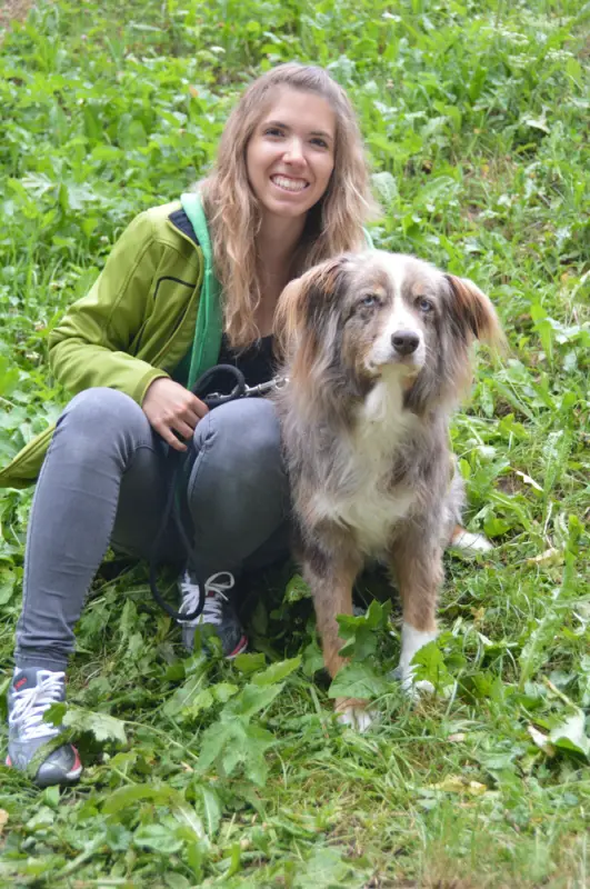 Eine Frau, die mit einem Hund im Gras sitzt. – Jugend und Hund Lager 2018 in Segnas