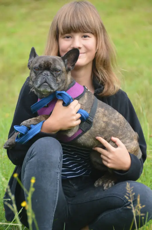 Ein Mädchen, das einen Hund in den Armen hält. – Jugend und Hund Lager 2018 in Segnas