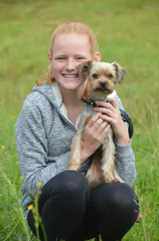 Ein Mädchen, das einen kleinen Hund in den Händen hält. – Jugend und Hund Lager 2018 in Segnas