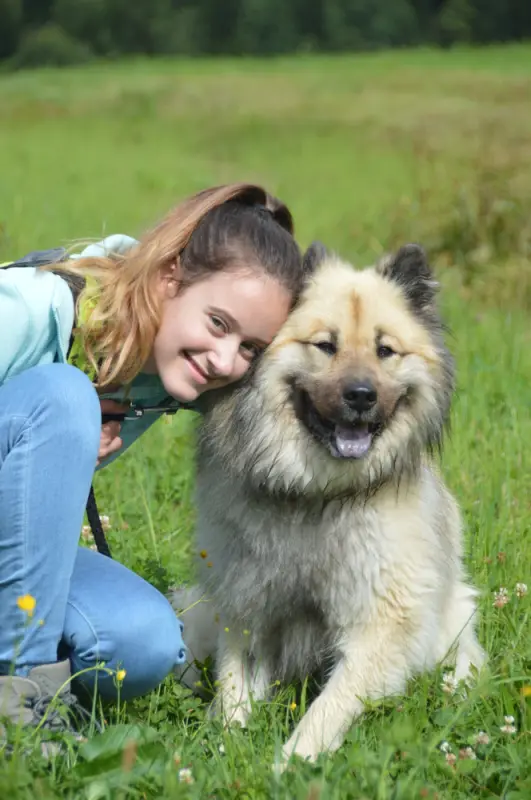Eine Frau, die neben einem Hund kniet. – Jugend und Hund Lager 2018 in Segnas