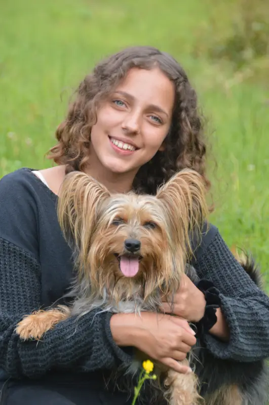 Eine Frau, die auf einem Feld mit einem Hund sitzt. – Jugend und Hund Lager 2018 in Segnas