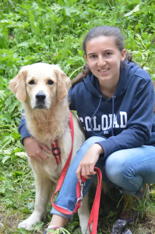 Eine Frau, die mit einem Hund niederkniet. – Jugend und Hund Lager 2018 in Segnas