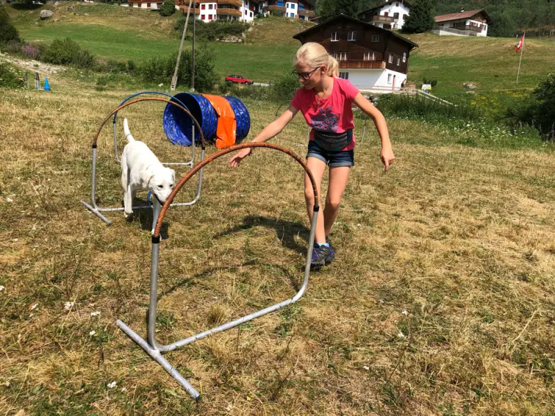 Ein junges Mädchen spielt mit einem Hund. – Jugend und Hund Lager 2019 in Segnas