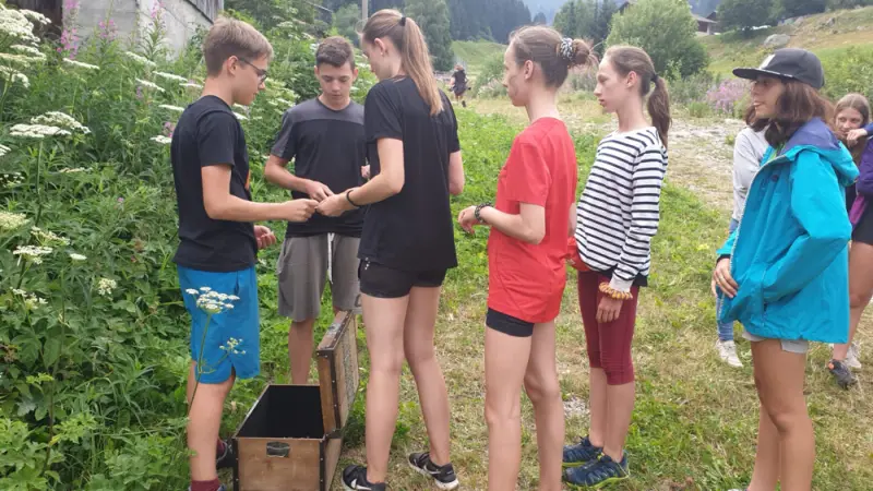 Eine Gruppe junger Leute, die um eine Kiste stehen. – Jugend und Hund Lager 2019 in Segnas