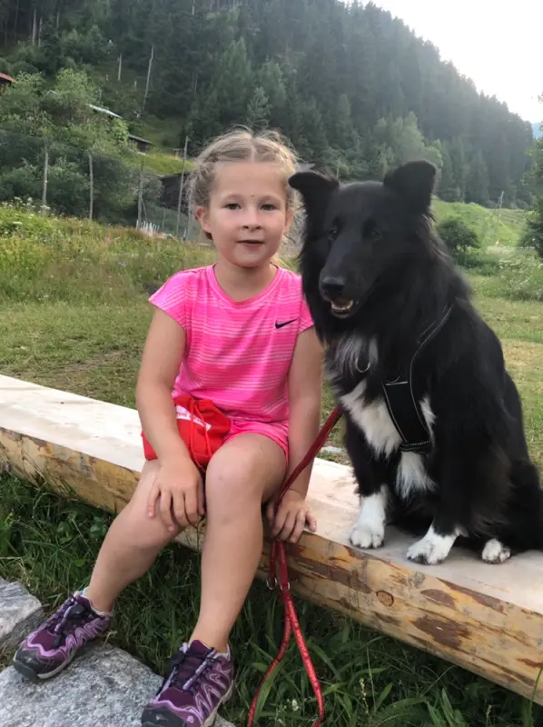 Ein kleines Mädchen sitzt auf einer Bank mit einem Hund. – Jugend und Hund Lager 2019 in Segnas